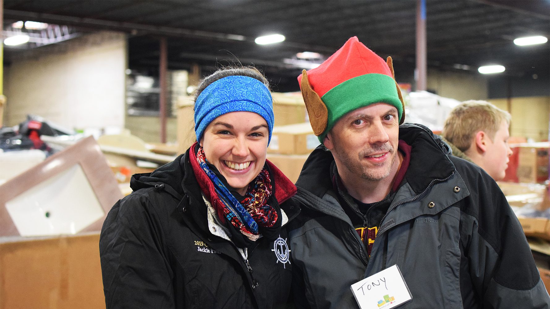 Two people smiling in a warehouse.