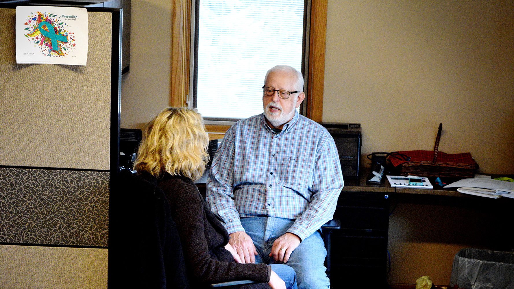 Man and woman talking in office.