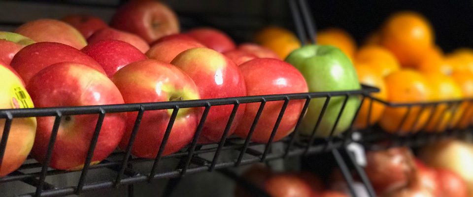 Red apples and oranges in baskets.